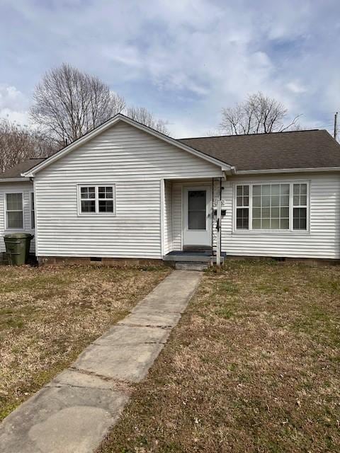 view of front of property with roof with shingles, crawl space, and a front yard