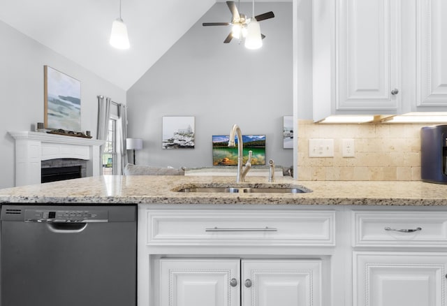 kitchen with light stone counters, a fireplace, white cabinetry, a sink, and dishwasher