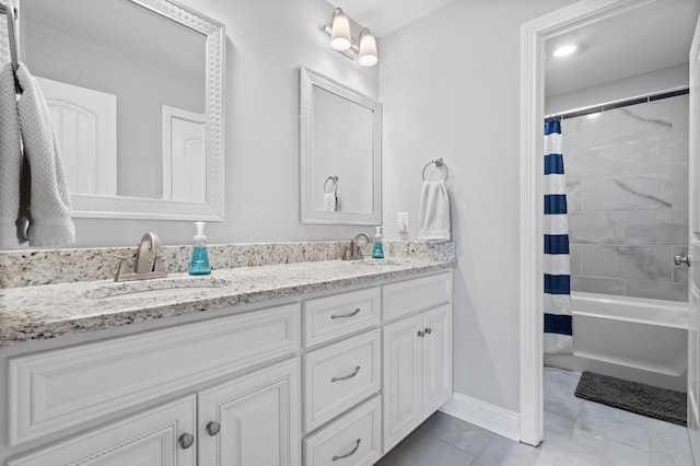 bathroom with double vanity, shower / bath combination with curtain, a sink, and baseboards