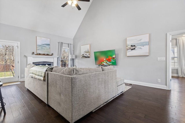 living area with high vaulted ceiling, dark wood finished floors, baseboards, and a ceiling fan