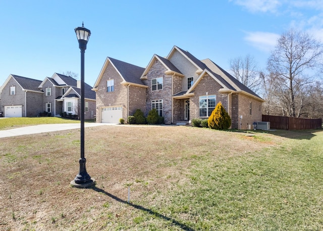 view of front of property with an attached garage, central air condition unit, brick siding, fence, and a front yard