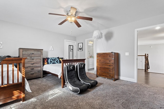 carpeted bedroom featuring ensuite bathroom, a ceiling fan, and baseboards