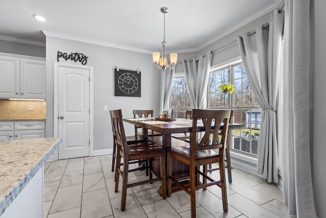 dining space featuring baseboards, a chandelier, and crown molding