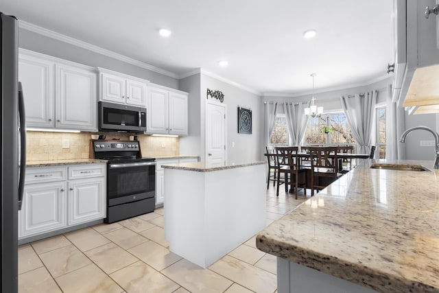 kitchen featuring stainless steel microwave, electric range oven, ornamental molding, freestanding refrigerator, and a sink