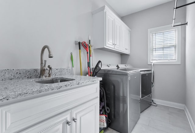 laundry area with light tile patterned flooring, a sink, baseboards, cabinet space, and washing machine and clothes dryer