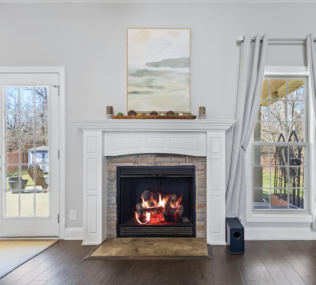 details with a warm lit fireplace, baseboards, and wood finished floors