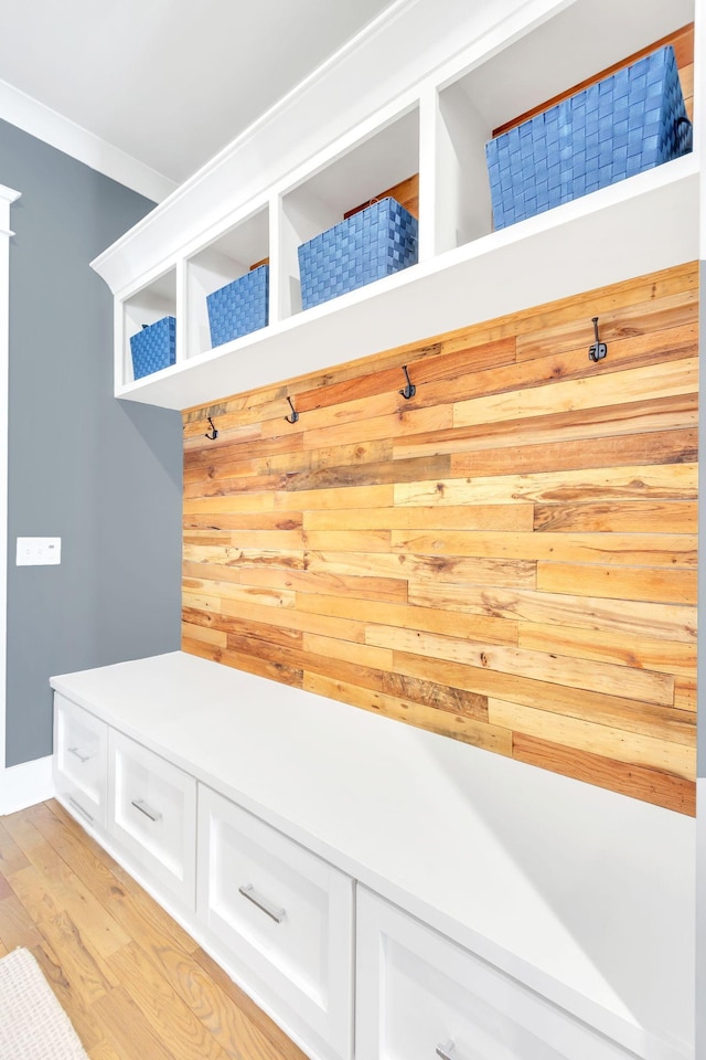 mudroom featuring ornamental molding and light wood-type flooring