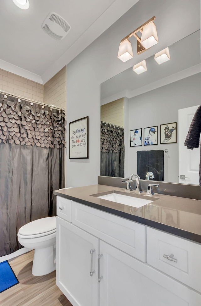 bathroom featuring toilet, wood finished floors, vanity, visible vents, and a shower with curtain