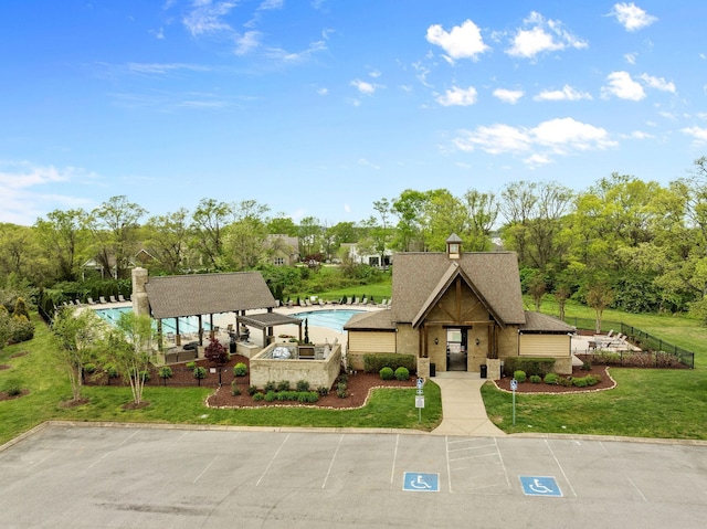 view of front of property featuring a front lawn and a community pool