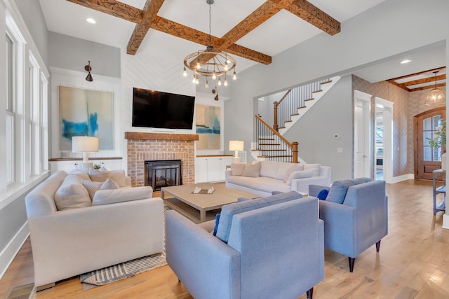 living area featuring light wood finished floors, baseboards, coffered ceiling, a chandelier, and beam ceiling