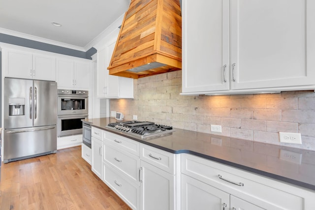 kitchen featuring dark countertops, custom exhaust hood, stainless steel appliances, crown molding, and backsplash