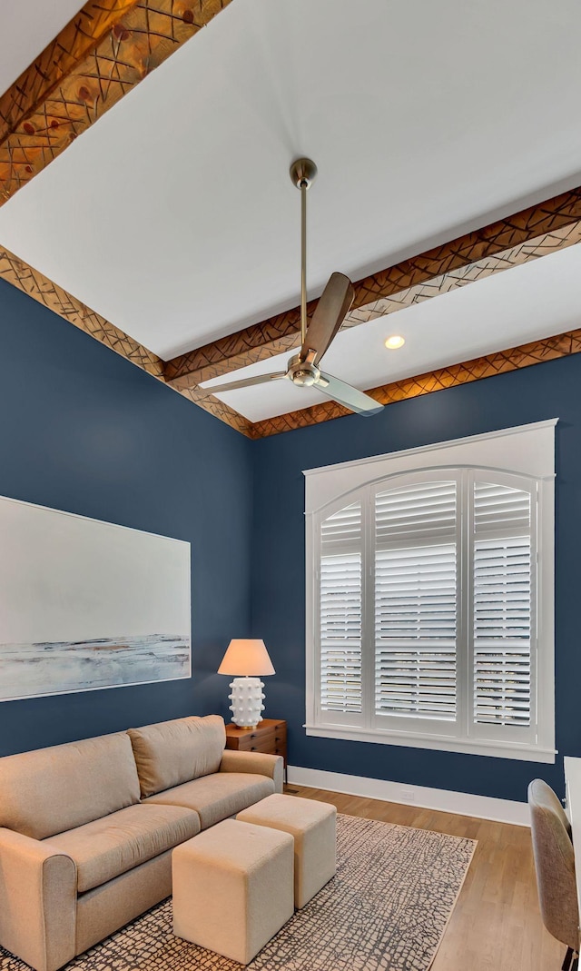 living room with beam ceiling, wood finished floors, a ceiling fan, and baseboards