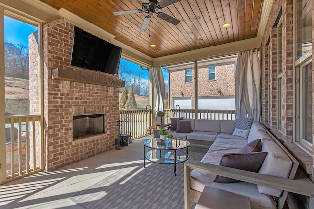 sunroom featuring ceiling fan, an outdoor brick fireplace, and wood ceiling