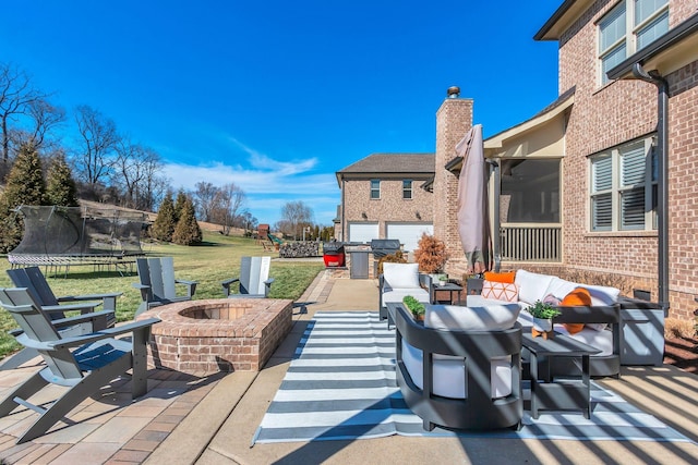 view of patio / terrace with a trampoline and an outdoor living space with a fire pit