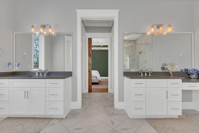 bathroom with marble finish floor, a marble finish shower, two vanities, and a sink