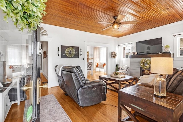 living area with wooden ceiling, ceiling fan, ornamental molding, and wood finished floors