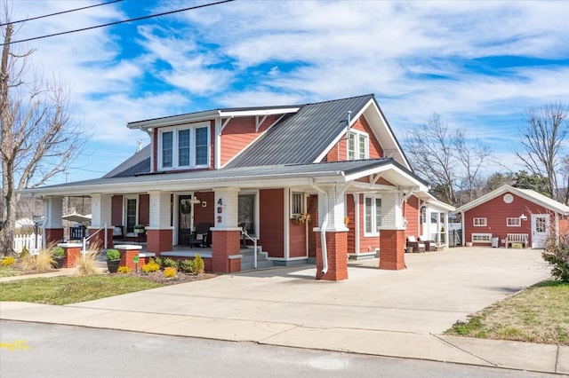 view of front of property with driveway, covered porch, and brick siding