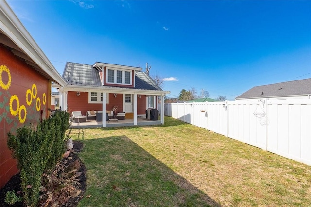 back of property with a patio area, a fenced backyard, outdoor lounge area, and a lawn