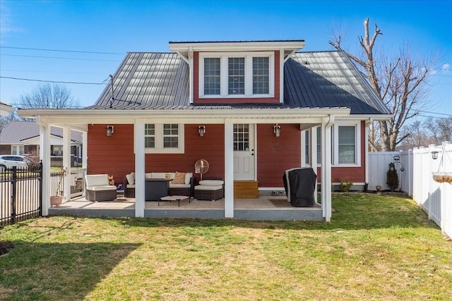 rear view of house with a patio area, a fenced backyard, an outdoor living space, and a lawn