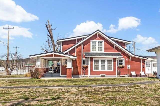 rear view of property featuring entry steps and a lawn