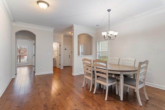 dining area featuring baseboards, dark wood finished floors, and crown molding