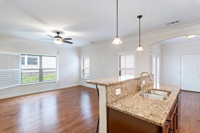 kitchen featuring arched walkways, visible vents, dark wood-type flooring, open floor plan, and a sink