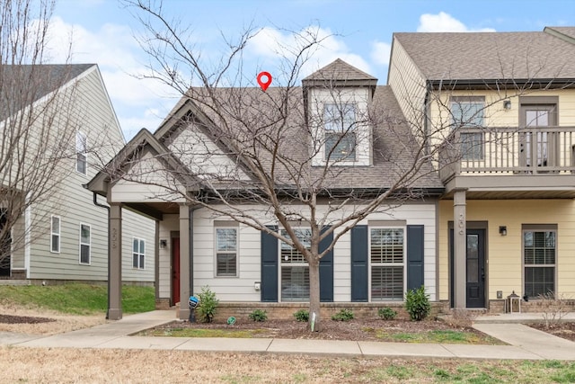 townhome / multi-family property featuring roof with shingles and brick siding