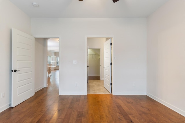 unfurnished room featuring hardwood / wood-style flooring, baseboards, and a ceiling fan