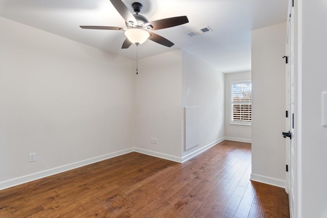 unfurnished room featuring ceiling fan, hardwood / wood-style floors, visible vents, and baseboards