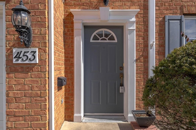 doorway to property featuring brick siding