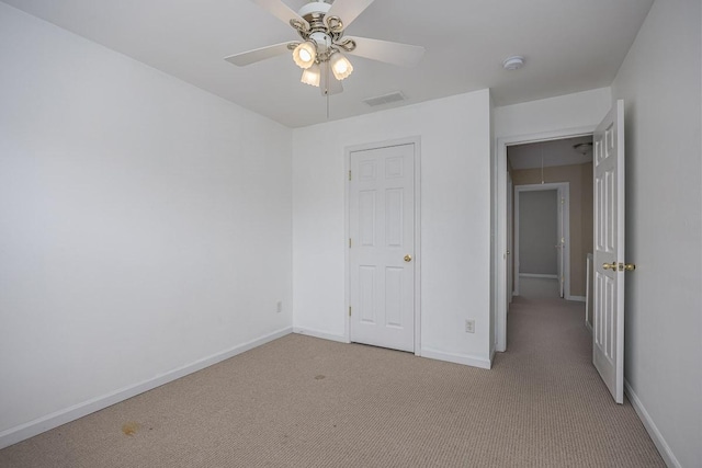 unfurnished bedroom with baseboards, light carpet, attic access, and visible vents