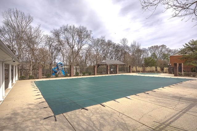 community pool with a gazebo, fence, playground community, and a patio