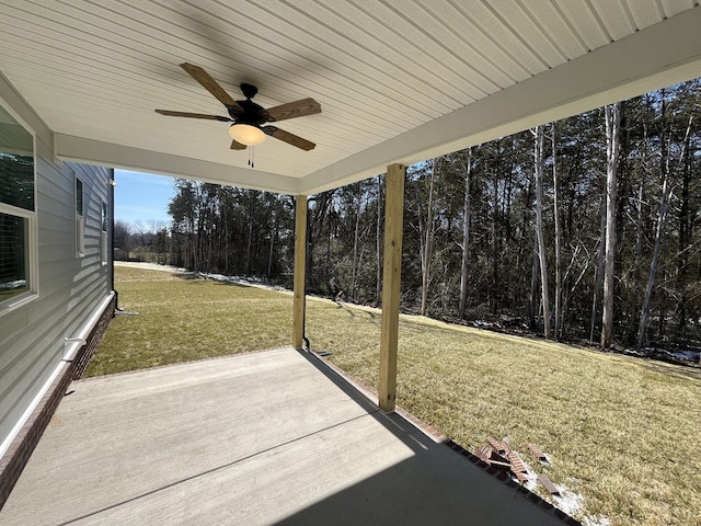 view of patio featuring a ceiling fan and a view of trees