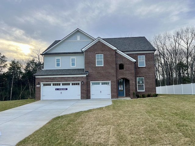 view of front facade featuring brick siding, fence, a front yard, driveway, and an attached garage