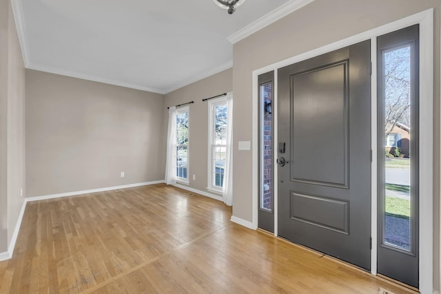 foyer with baseboards, light wood-type flooring, and crown molding