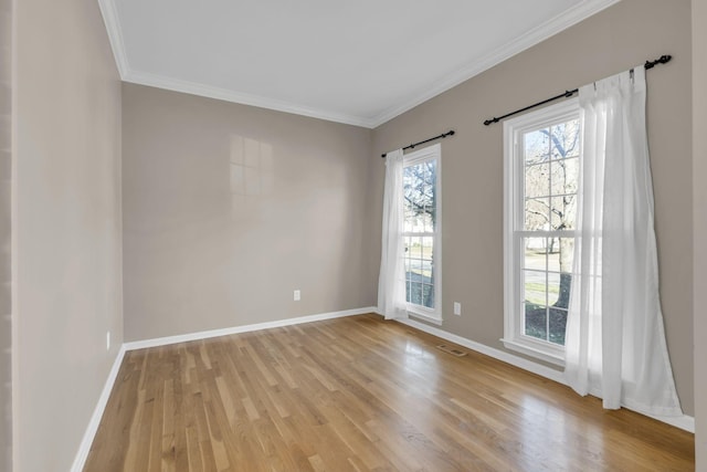 unfurnished room with light wood-style floors, crown molding, and baseboards