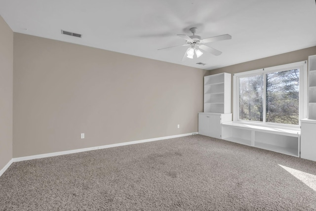 carpeted empty room featuring baseboards, visible vents, and ceiling fan