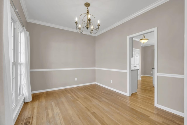 spare room featuring visible vents, crown molding, light wood-style flooring, and baseboards