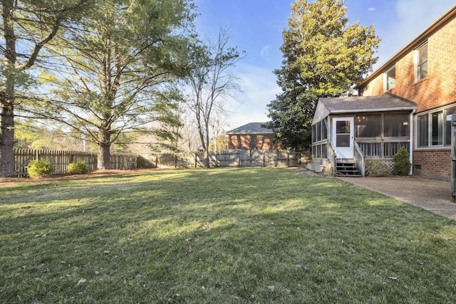 view of yard with a patio area, a sunroom, and a fenced backyard