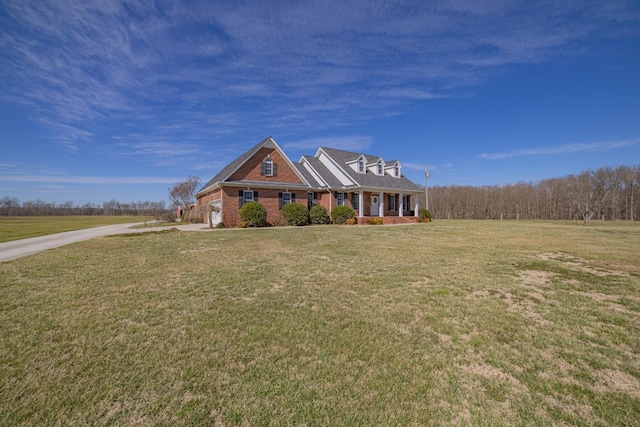 view of front facade with an attached garage, brick siding, and a front yard