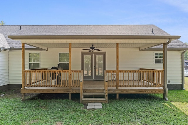 back of house with a shingled roof, french doors, and a yard