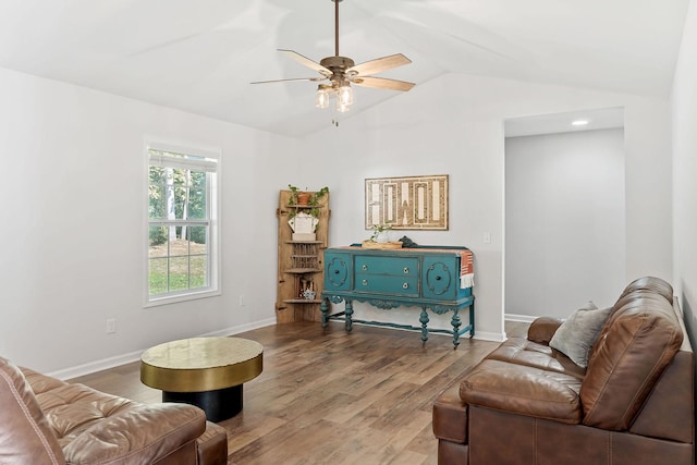 living area featuring lofted ceiling, wood finished floors, a ceiling fan, and baseboards