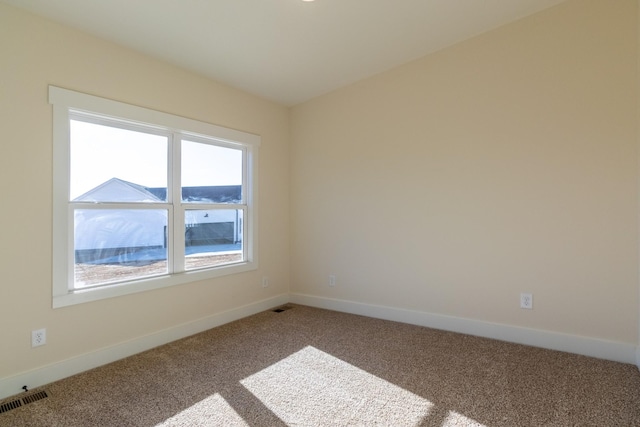 empty room featuring baseboards, visible vents, and carpet flooring