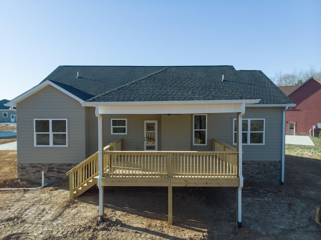 back of property featuring a wooden deck and roof with shingles