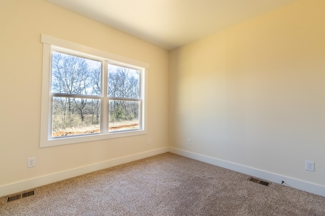 carpeted empty room featuring visible vents and baseboards