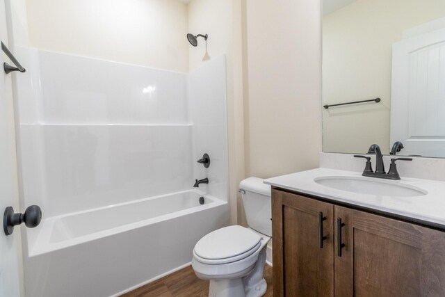 bathroom featuring wood finished floors, shower / bath combination, vanity, and toilet