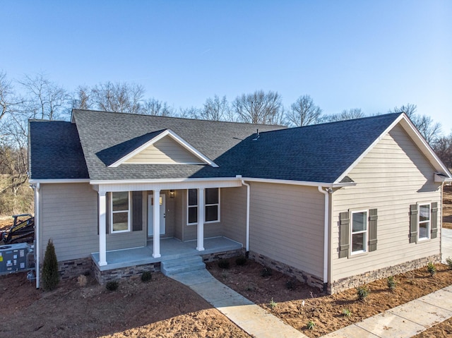 view of front of property with covered porch and roof with shingles