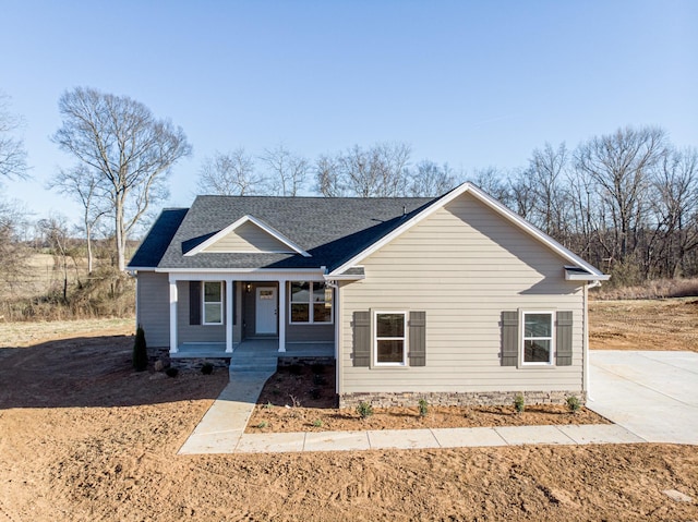 view of front of house with a porch and a shingled roof