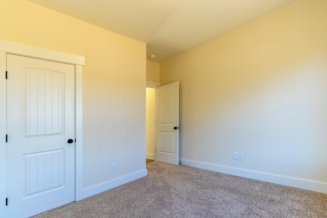 unfurnished bedroom featuring carpet floors, a closet, and baseboards