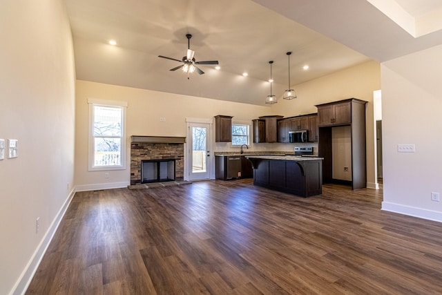 kitchen featuring dark wood finished floors, appliances with stainless steel finishes, open floor plan, ceiling fan, and dark brown cabinets